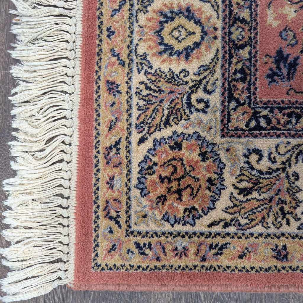Elegant area rug featuring detailed floral designs and a decorative fringe, suitable for living rooms or bedrooms.