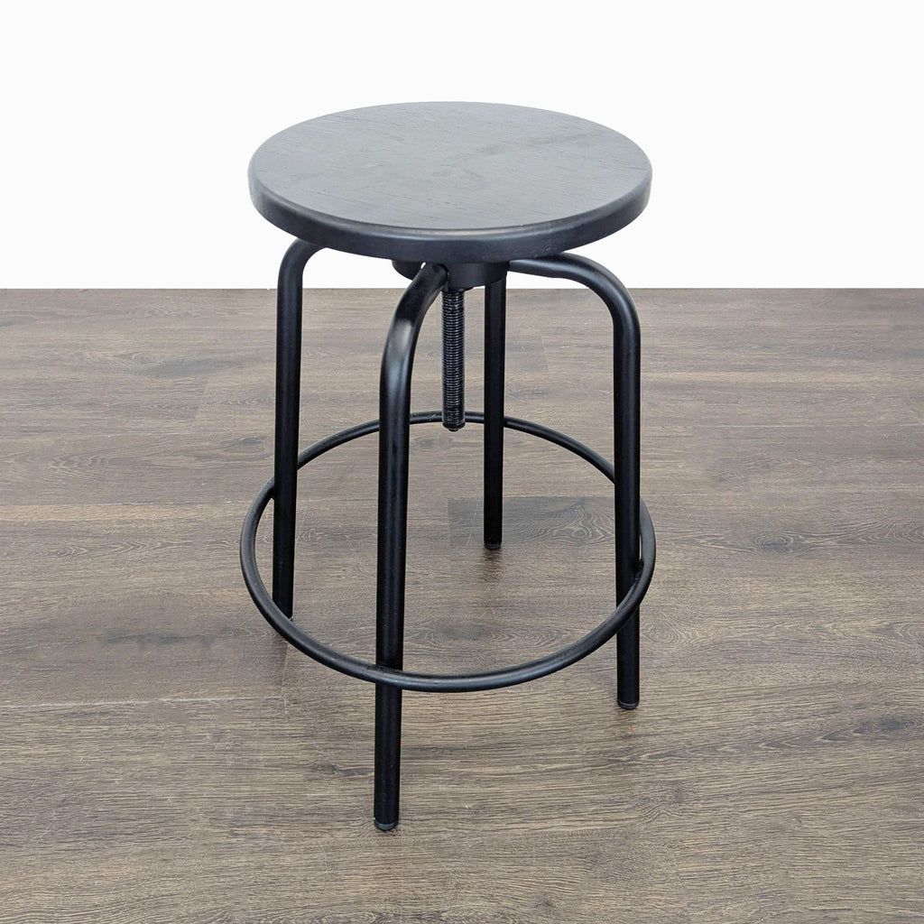 2. Single black industrial-style stool with round seat and sturdy metal frame, ideal for modern spaces.