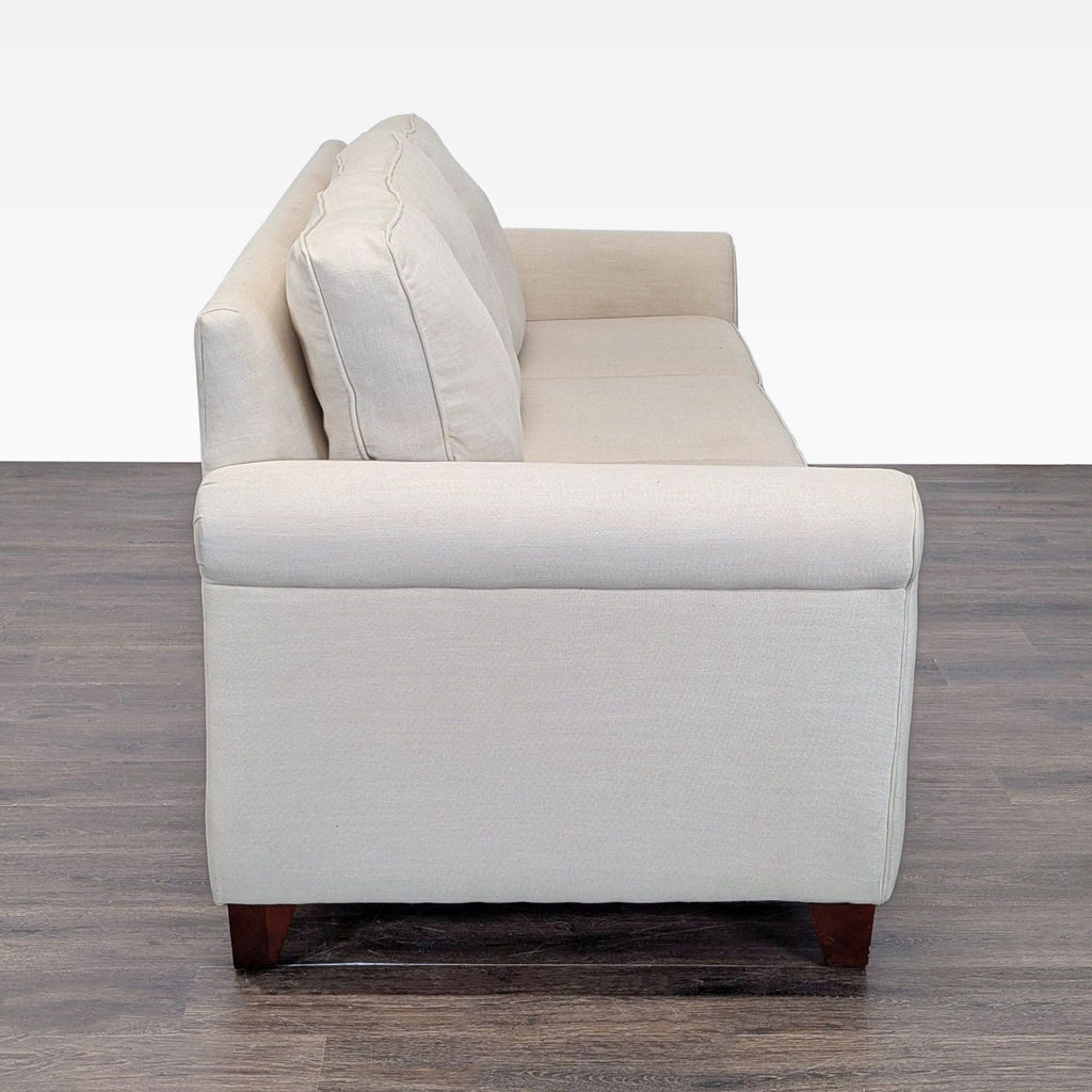 Three-seat Pottery Barn sofa in neutral fabric with rolled arms, ideal for living rooms or guest areas.