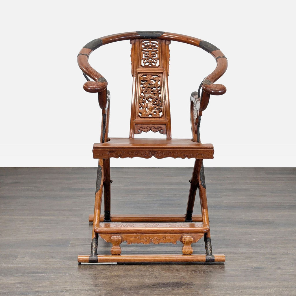Traditional wood lounge armchair with horseshoe back, carved motifs, and metal accents; folding design.