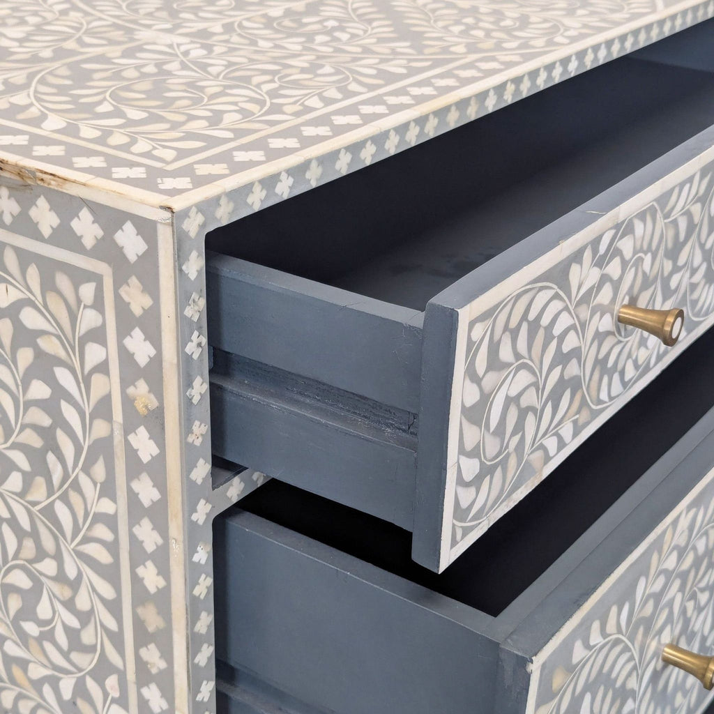 Modern dresser with detailed floral bone inlay, sturdy metal legs, and three large drawers for storage.