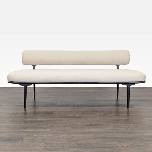 CB2 cream sofa with slim backrest, black metal legs, and minimalist frame for modern spaces.