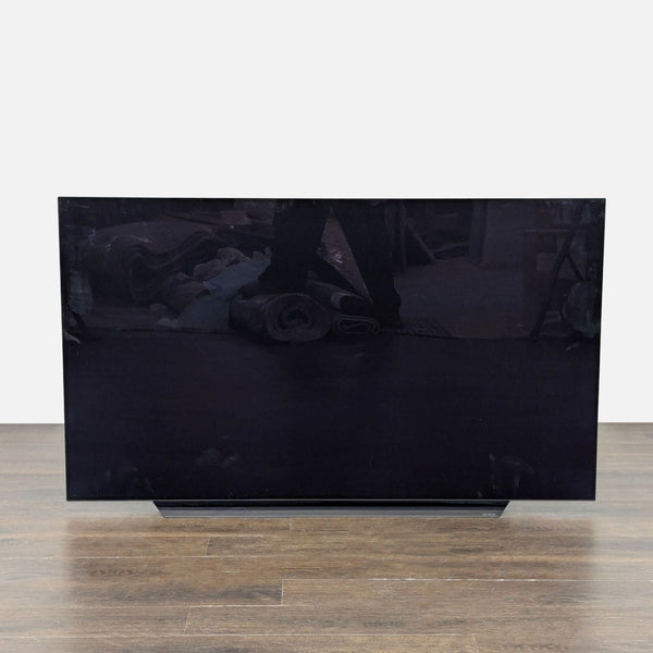 LG 55-inch smart TV with slim frame, displaying artwork in a modern living room setting.