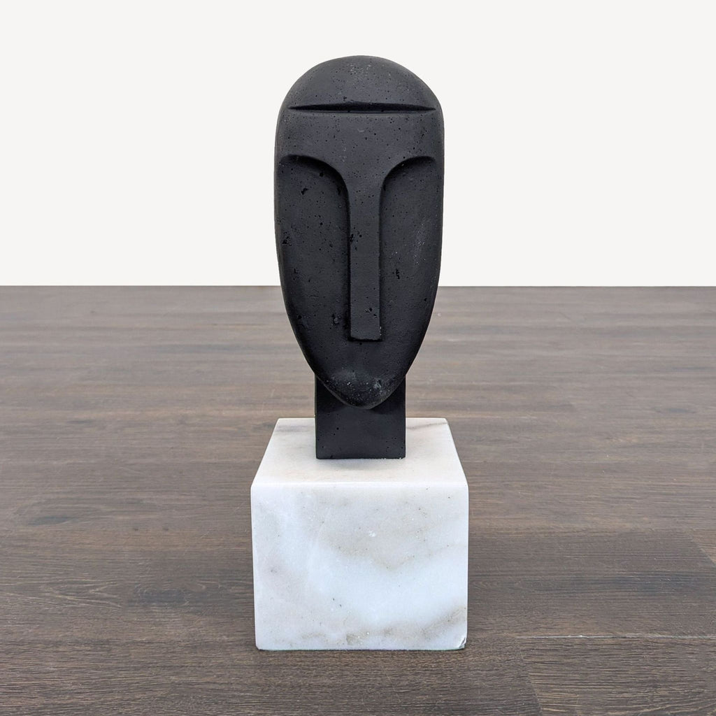 Abstract face sculpture by Arteriors Home with a smooth finish on a white marble base for modern decor.  