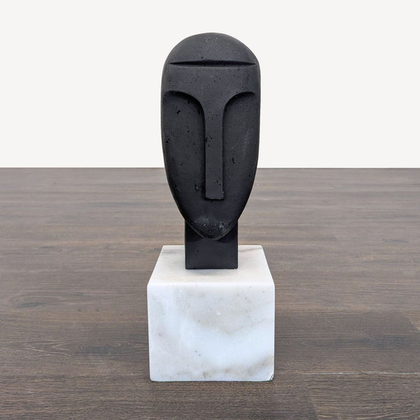 Abstract face sculpture by Arteriors Home with a smooth finish on a white marble base for modern decor.  