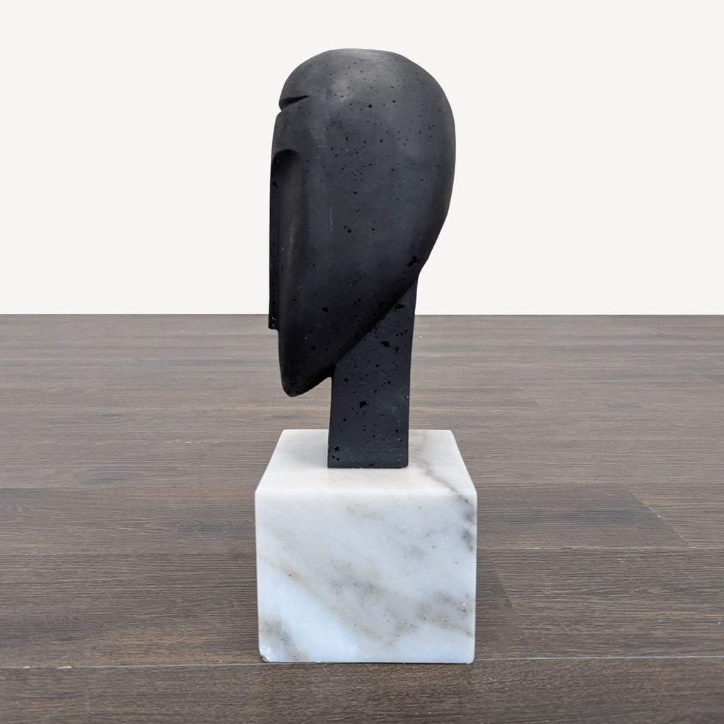 Modern sculpture featuring an abstract face design, set on a solid marble base, by Arteriors Home.  