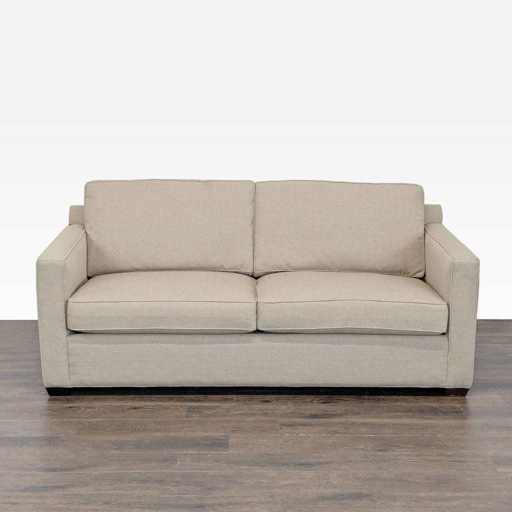 Crate & Barrel beige sleeper sofa with straight arms, offering modern style and converts into a bed for guests.  
