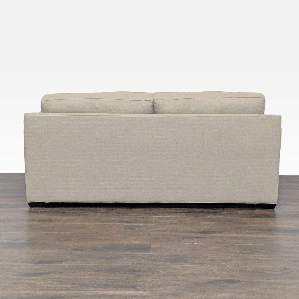 Modern Crate & Barrel sleeper sofa in beige, serves as both comfortable seating and a convenient guest bed.