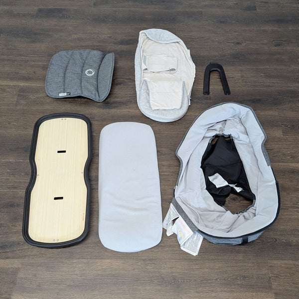 Bugaboo Fox2 bassinet fabric set in neutral gray with included mattress, board, and handle, shown without frame.