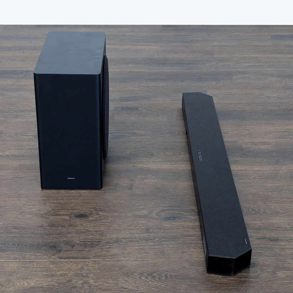 Side angle of Samsung soundbar and subwoofer, both in black, designed for premium TV and music sound.