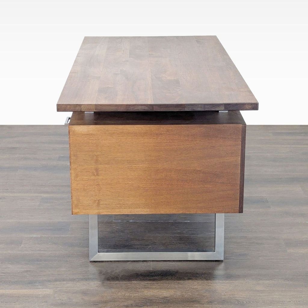 Side view of a Crate & Barrel walnut and metal desk highlighting the contemporary design and thick floating tabletop.