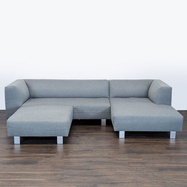1. Gray Room and Board sectional sofa with ottoman and metal legs, featuring modern low-profile arms on hardwood floor.