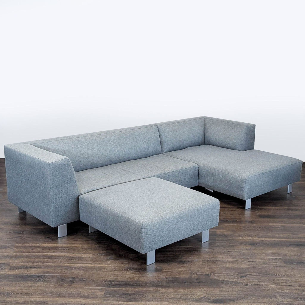 2. Modern gray fabric Room and Board sectional with ottoman, metal legs, and clean lines, ideal for contemporary spaces.