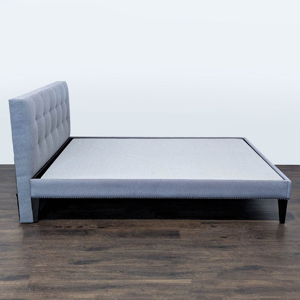 Modern West Elm Queen frame with comfortable tufted headboard, stylish grey upholstery, and durable support.