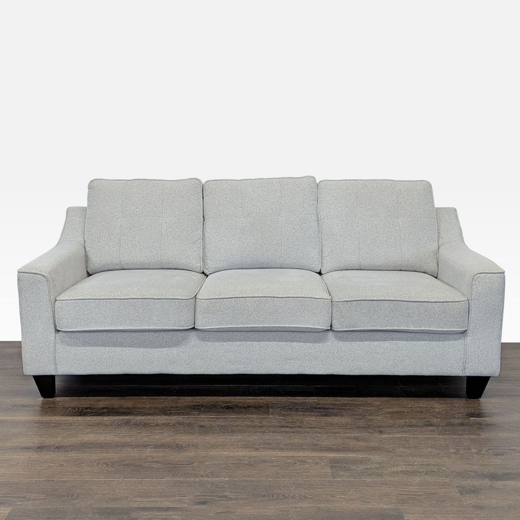 1. Living Spaces 3-seat sofa in light gray fabric with plush cushions and clean lines, ideal for any living room.