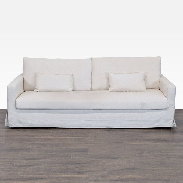 1. Front view of an IKEA 3-seat sofa with a light beige removable slipcover and two matching lumbar pillows.