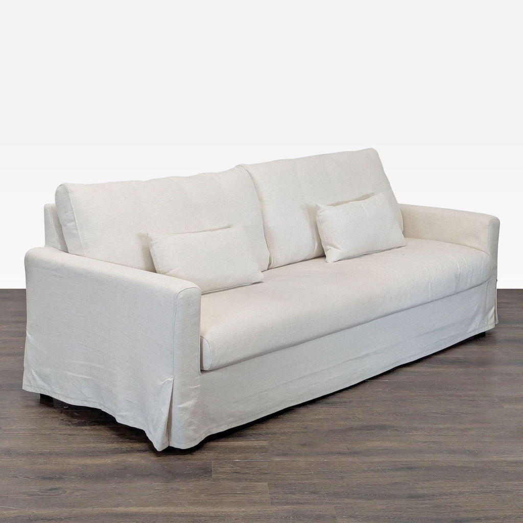 2. Angled side view showing the modern design and soft cushions of an IKEA beige 3-seat sofa with lumbar pillows.