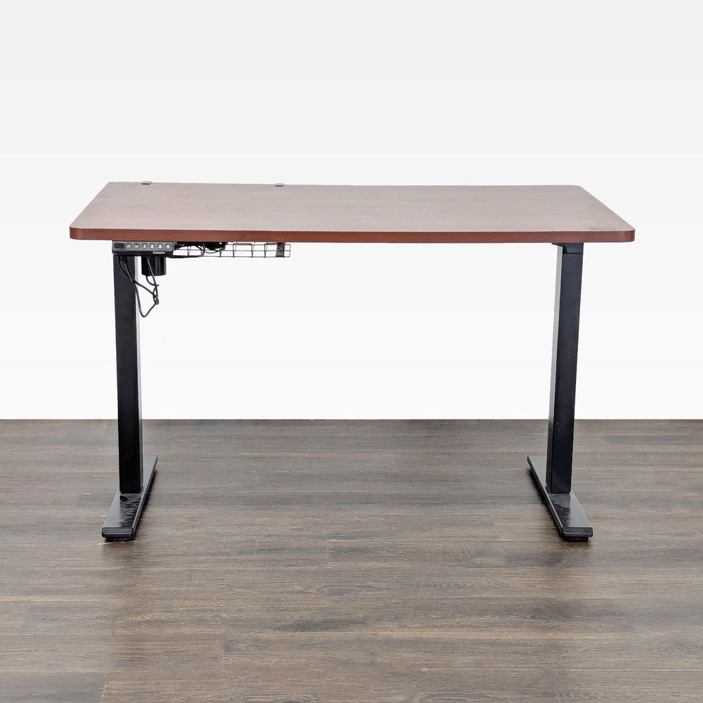 Flexispot desk with wood top, black frame, and electric height controls; includes cable tray and preset buttons.  
