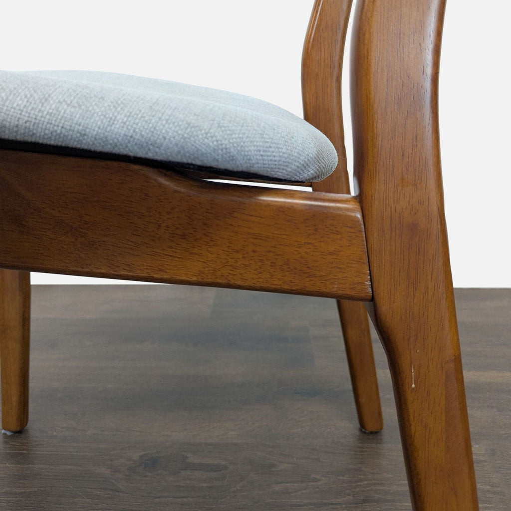 3. Close-up of West Elm dining chair’s wood frame and light upholstered seat, highlighting grain and texture.