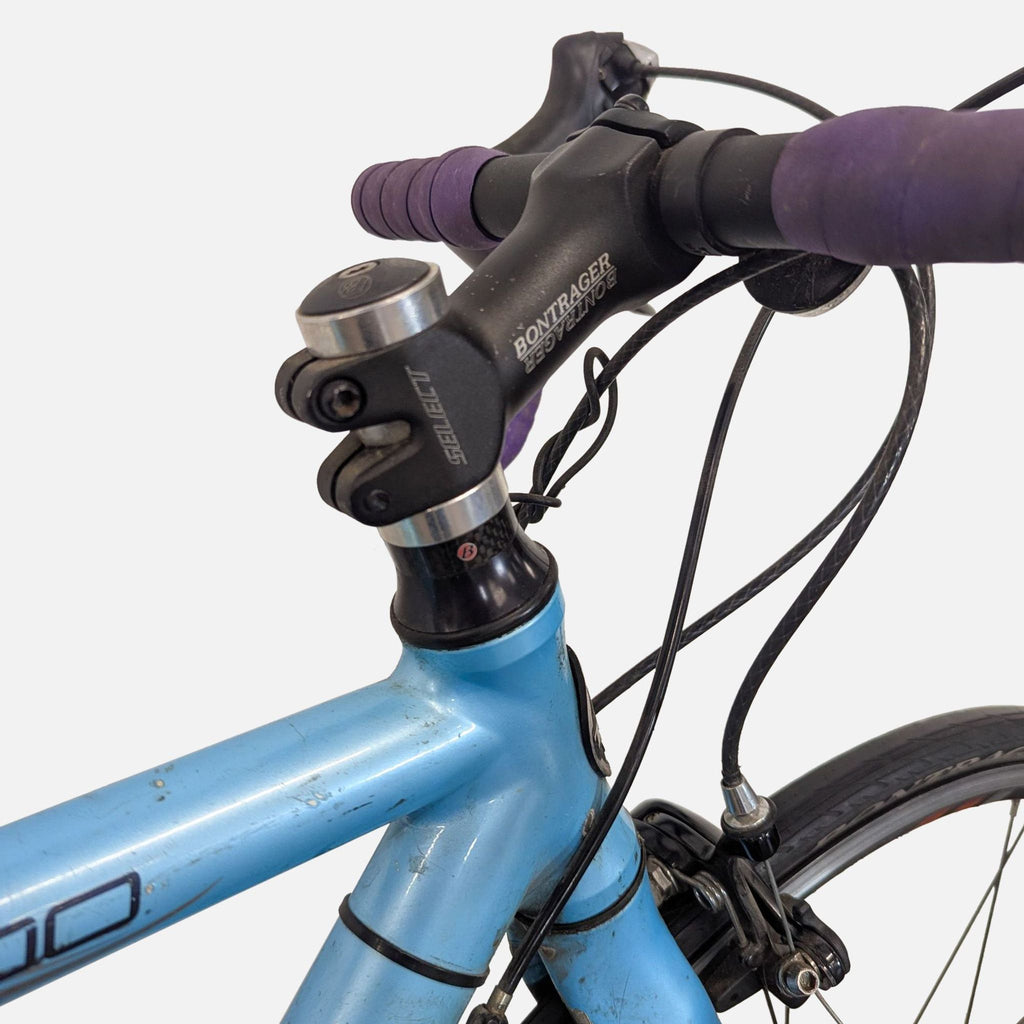 3. Detail of the Trek 1500’s handlebar and Bontrager stem, highlighting the purple bar tape and used condition.