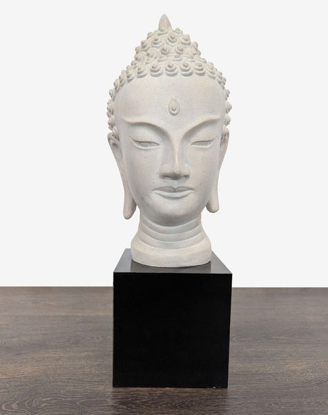 1. Light-toned Buddha head sculpture with a serene expression, set on a black base for tabletop display.