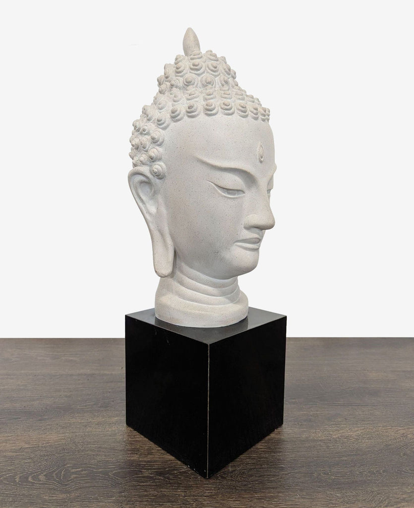 2. Calm Buddha head statue on a sleek black stand, ideal for adding peaceful decor to any room.