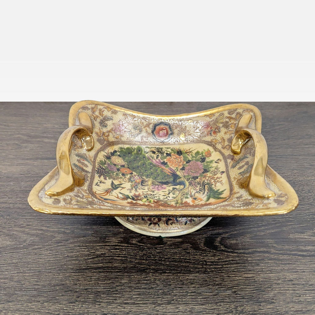 Decorative footed dish featuring hand-painted peacock, floral motifs, and elaborate gilded handles.  