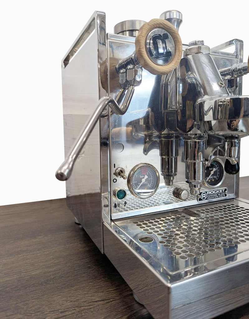 Rocket brand espresso maker with dual gauges, steam wand, and sleek stainless steel and wood design.