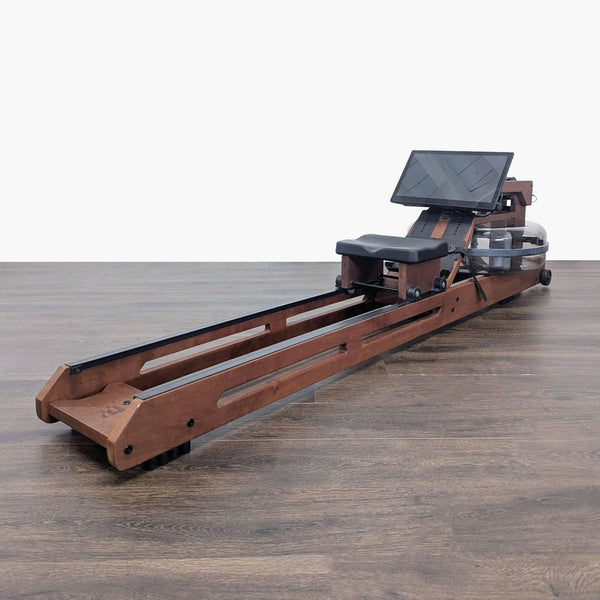 1. Wooden WaterRower rowing machine with water resistance, fitness monitor, and adjustable footrests, folded upright to save space.  