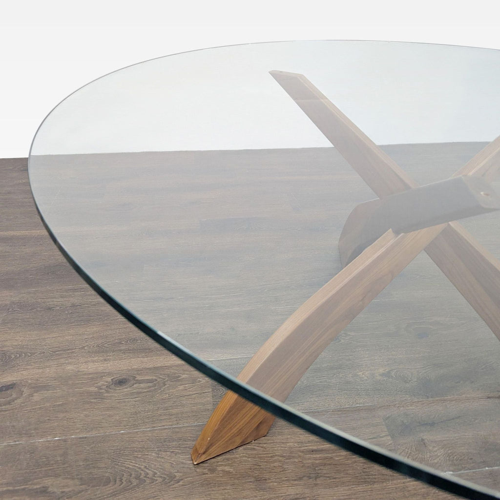 2. Close-up of glass-topped dining table, highlighting the smooth, curved wooden base.