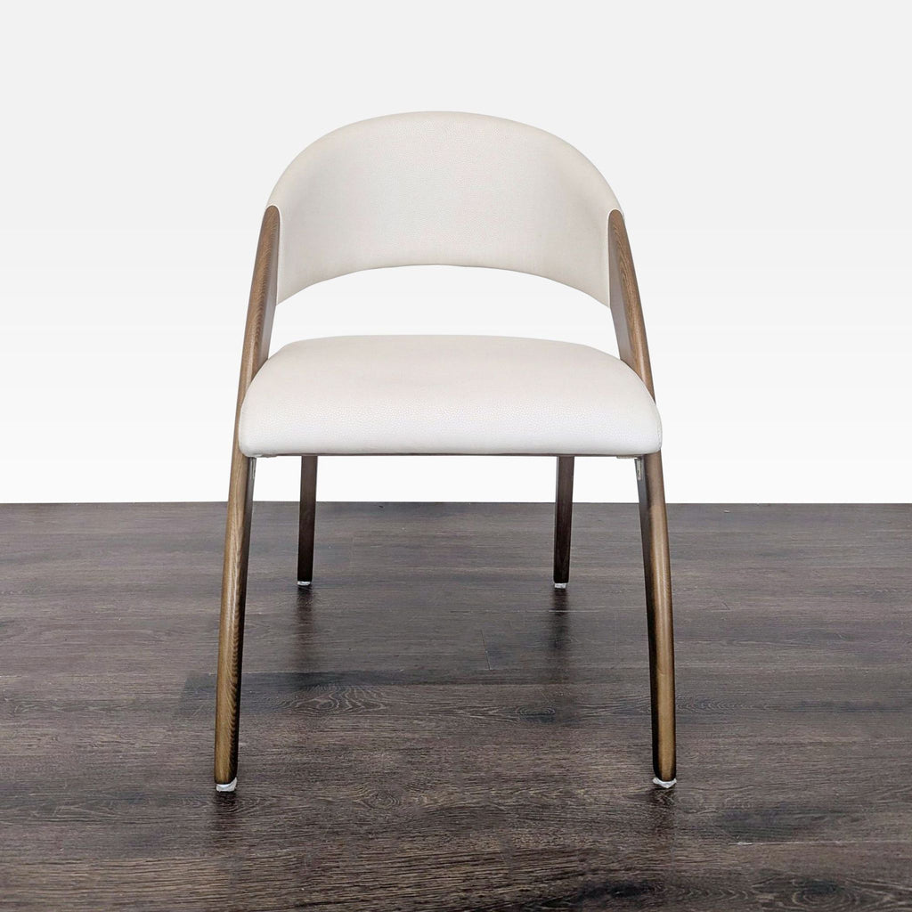 Dining chair featuring a tapered walnut ash frame and cream vegan leather covering the seat and backrest.