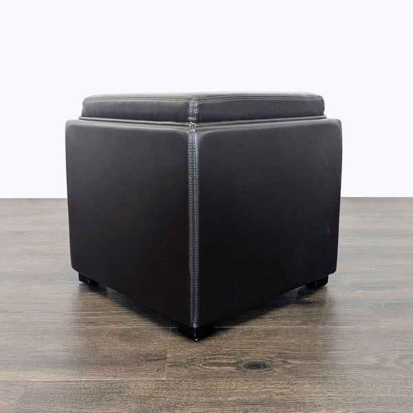 Bonded leather ottoman with lift-top tray, featuring ebony-stained surface and sturdy hardwood frame.