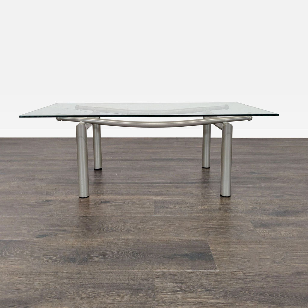 1. Modern coffee table with rectangular glass top and silver metal legs on a wooden floor background.
