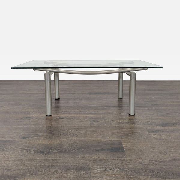 1. Modern coffee table with rectangular glass top and silver metal legs on a wooden floor background.