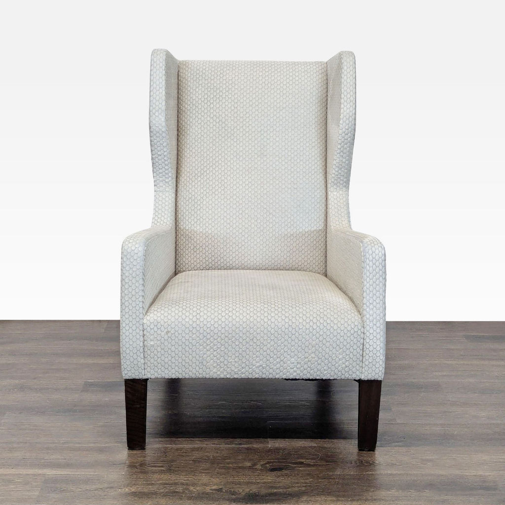 Front view of a cream, textured wingback lounge chair with dark wooden legs by Holly Hunt.  