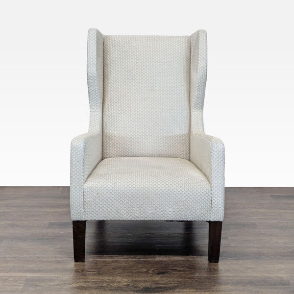 Front view of a cream, textured wingback lounge chair with dark wooden legs by Holly Hunt.  