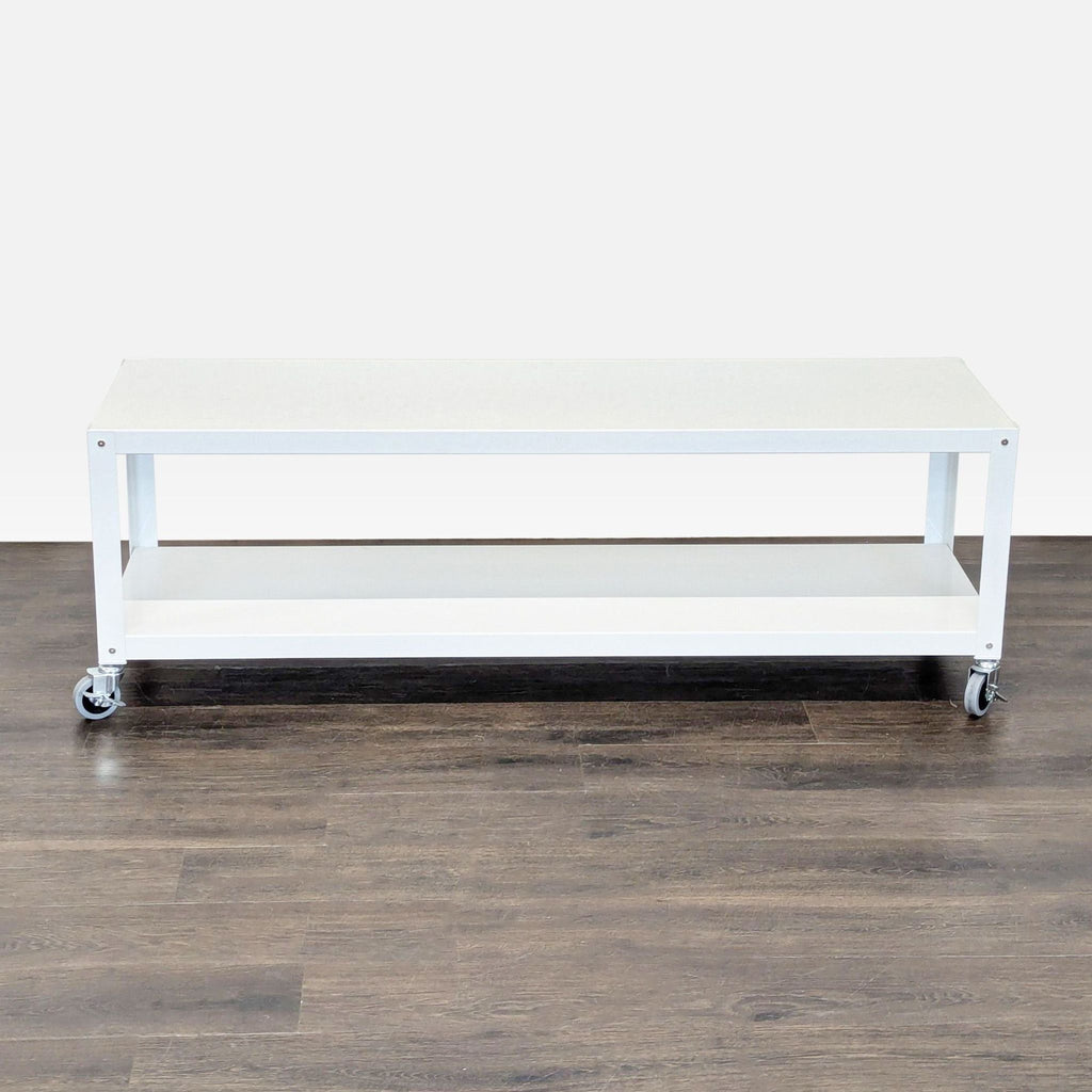 White rectangular coffee table with wheels and bottom shelf, placed on dark wood flooring.  