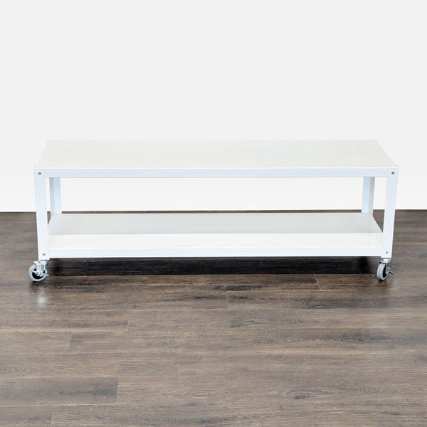 White rectangular coffee table with wheels and bottom shelf, placed on dark wood flooring.  