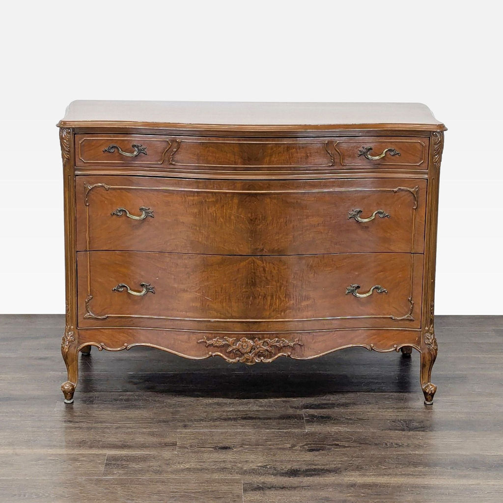 Curved-front wood dresser by John Stuart Inc. with three drawers, vintage handles, and carved detail.