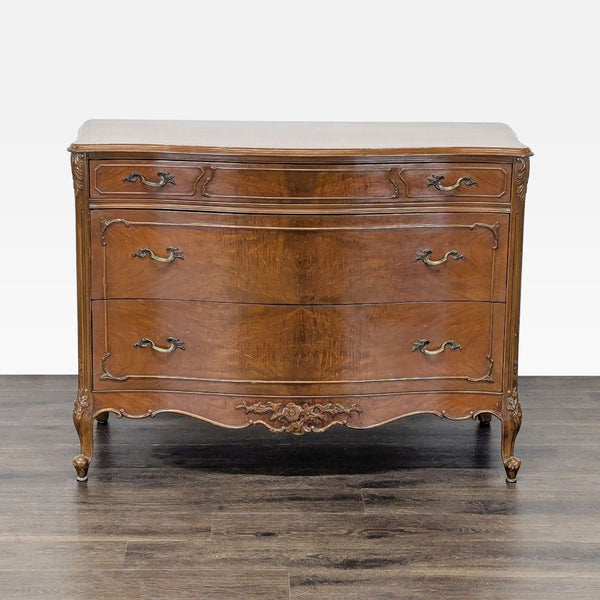 Curved-front wood dresser by John Stuart Inc. with three drawers, vintage handles, and carved detail.