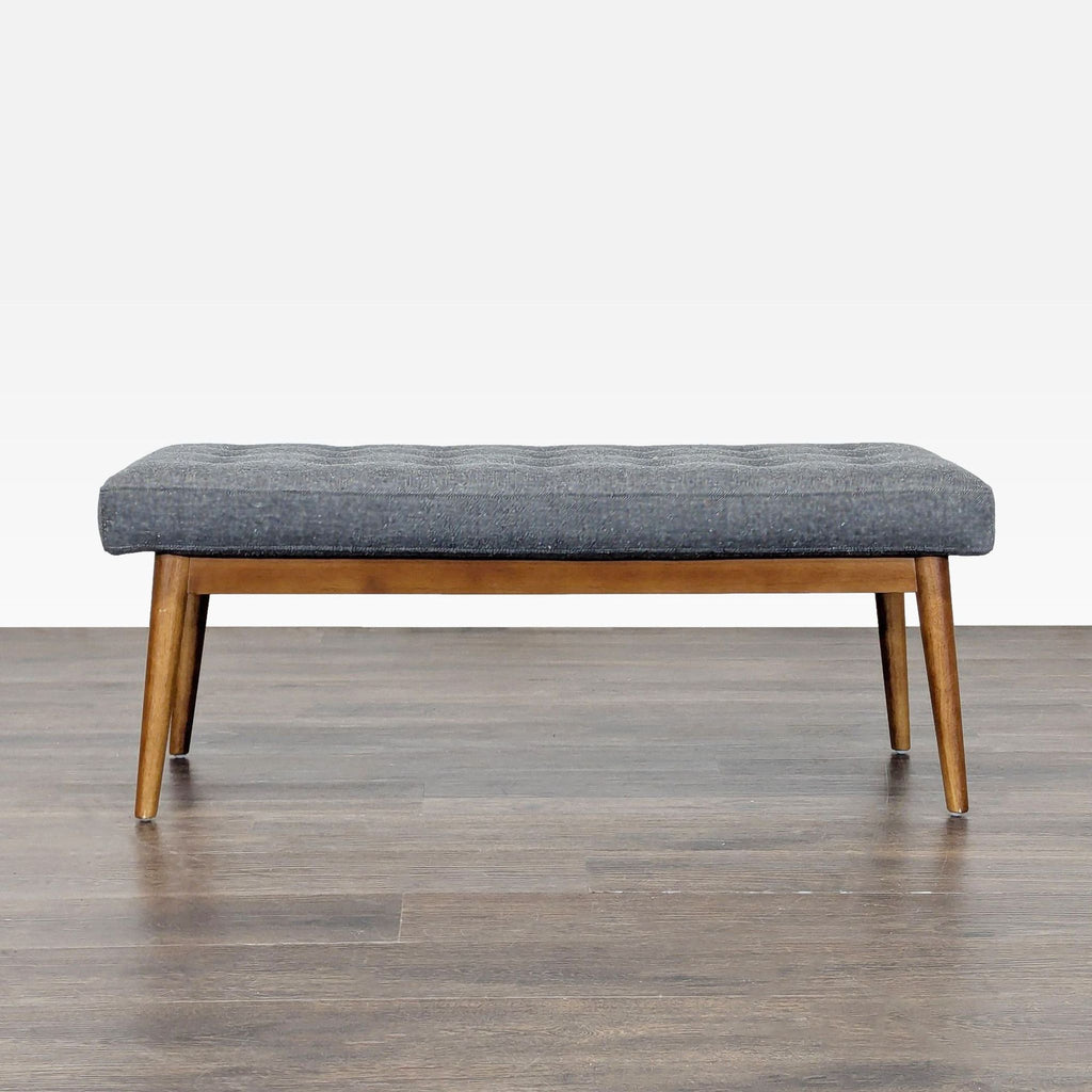 3. Side view of a modern West Elm bench featuring soft gray upholstery and tapered wood legs, stylish for home entryways.