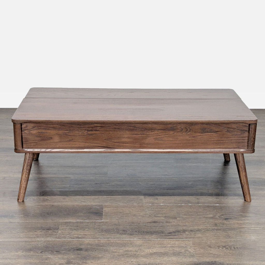 3. Rectangular wood coffee table with minimalist design, flush drawers, and splayed legs, on a wood floor.