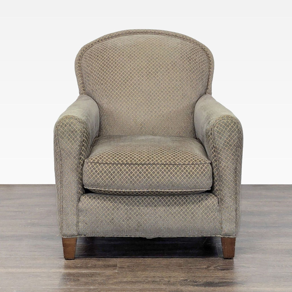 Crate & Barrel lounge chair with patterned neutral upholstery and wooden legs, showing minor wear.