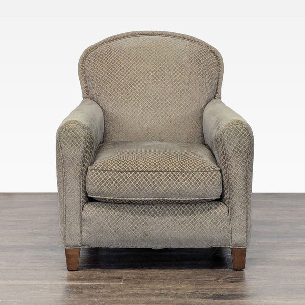 Crate & Barrel lounge chair with patterned neutral upholstery and wooden legs, showing minor wear.