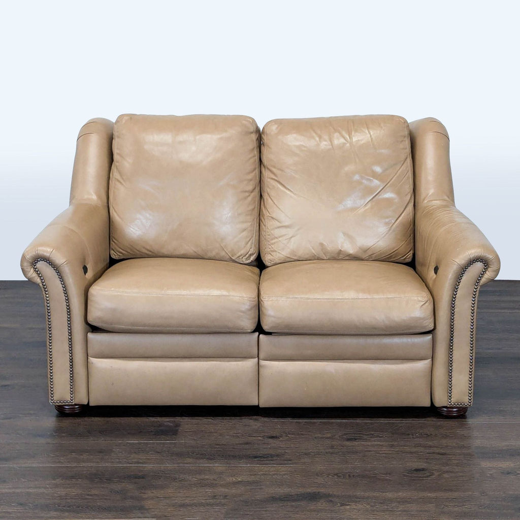 Bradington-Young loveseat in soft tan leather with nailhead trim and dual reclining seats.