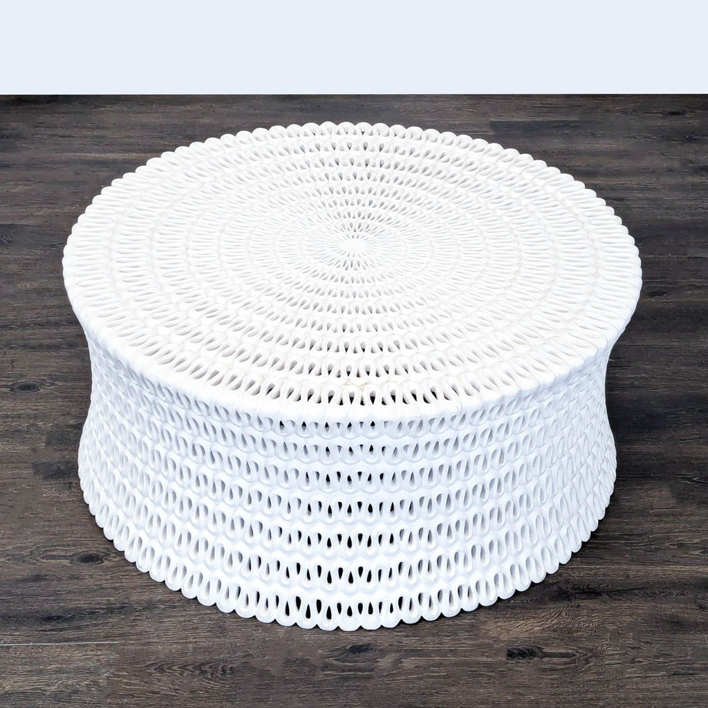 3. Artistic round coffee table from Oly Studio in pierced white cast resin with a repeating looped pattern design.