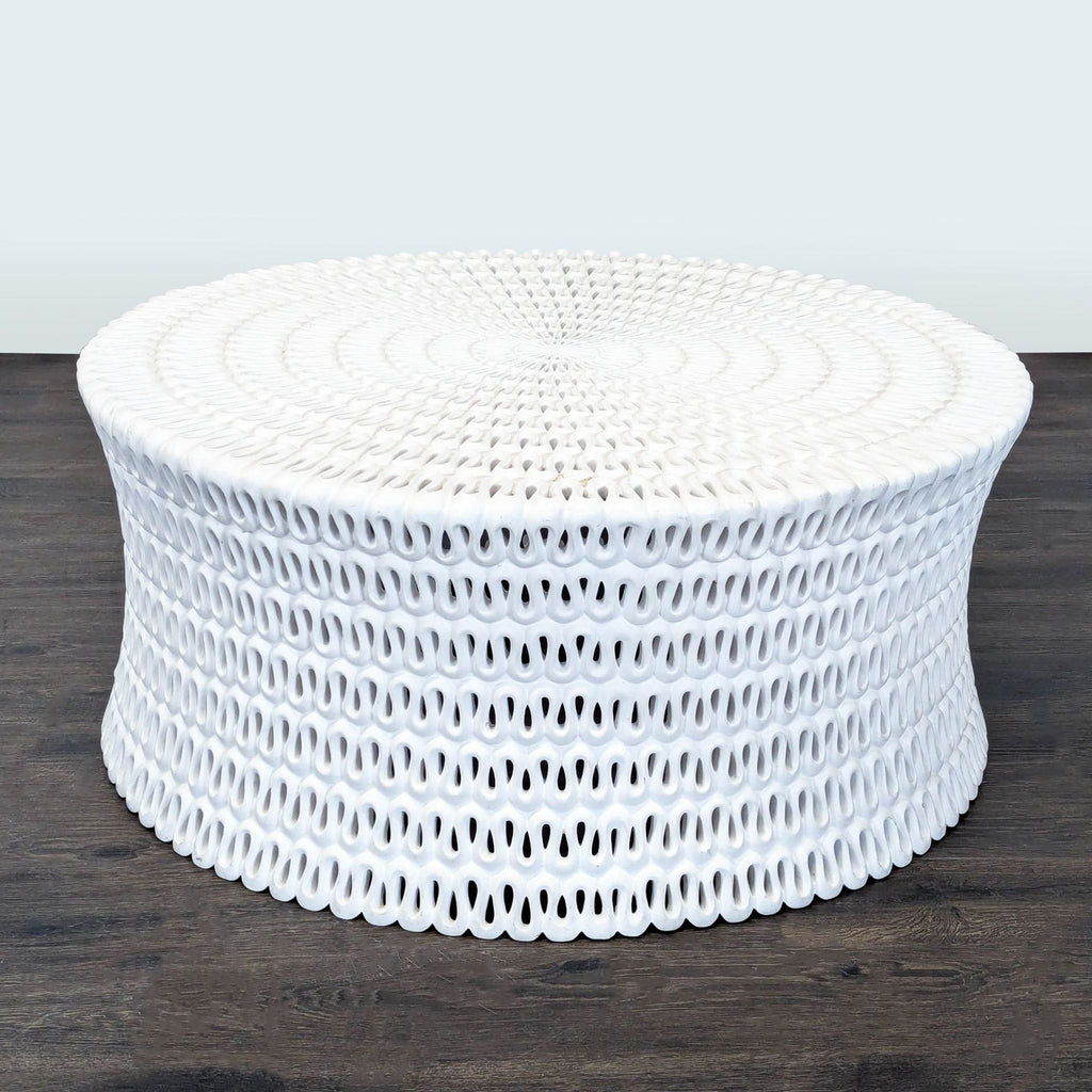 1. White pierced cast resin coffee table by Oly Studio, round with intricate woven-like pattern on dark floor.  