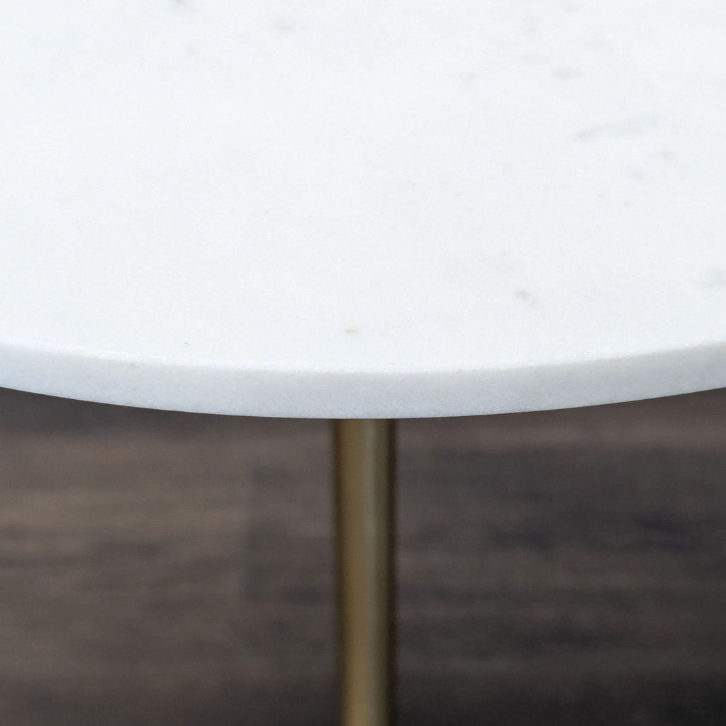 Marble-topped side or console table featuring a sculptural metal base in antique brass finish by West Elm.  