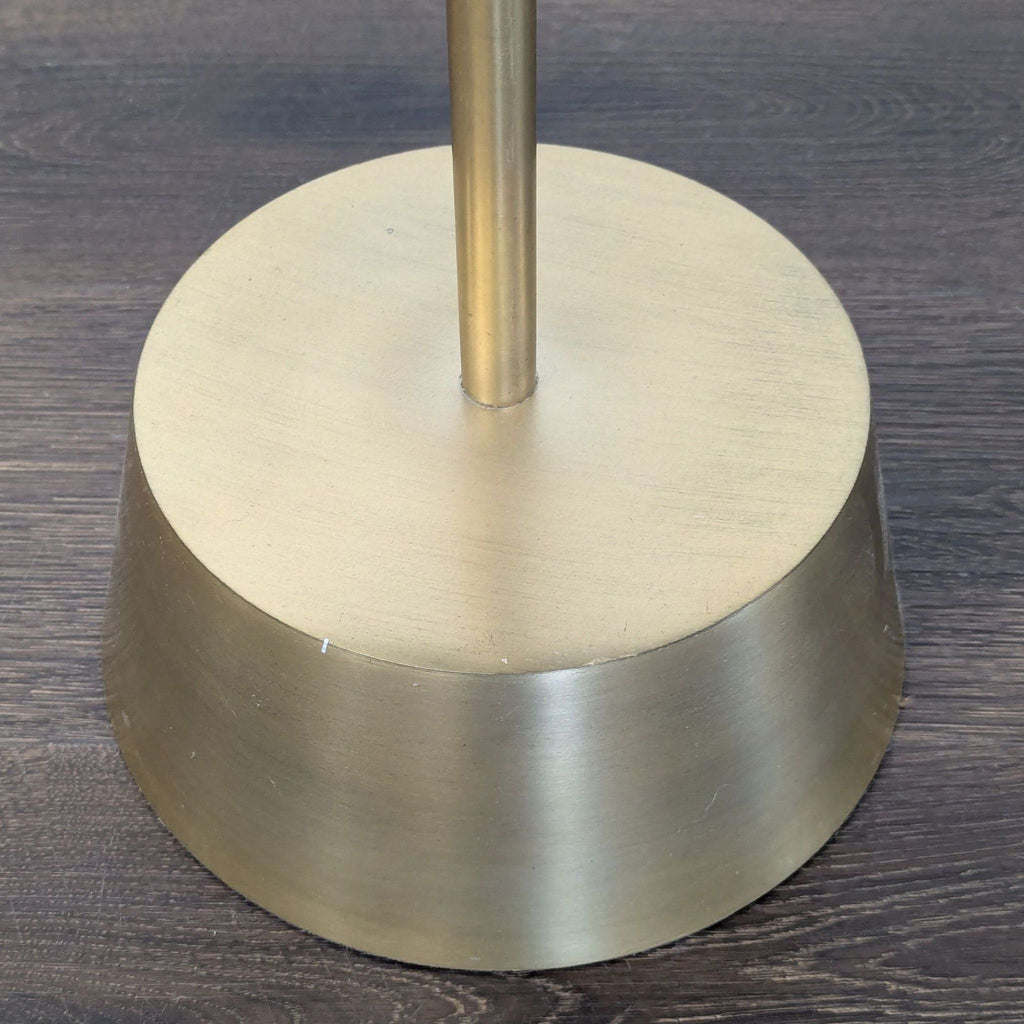 Sculptural metal base in antique brass supports a marble top on this West Elm side/console table.