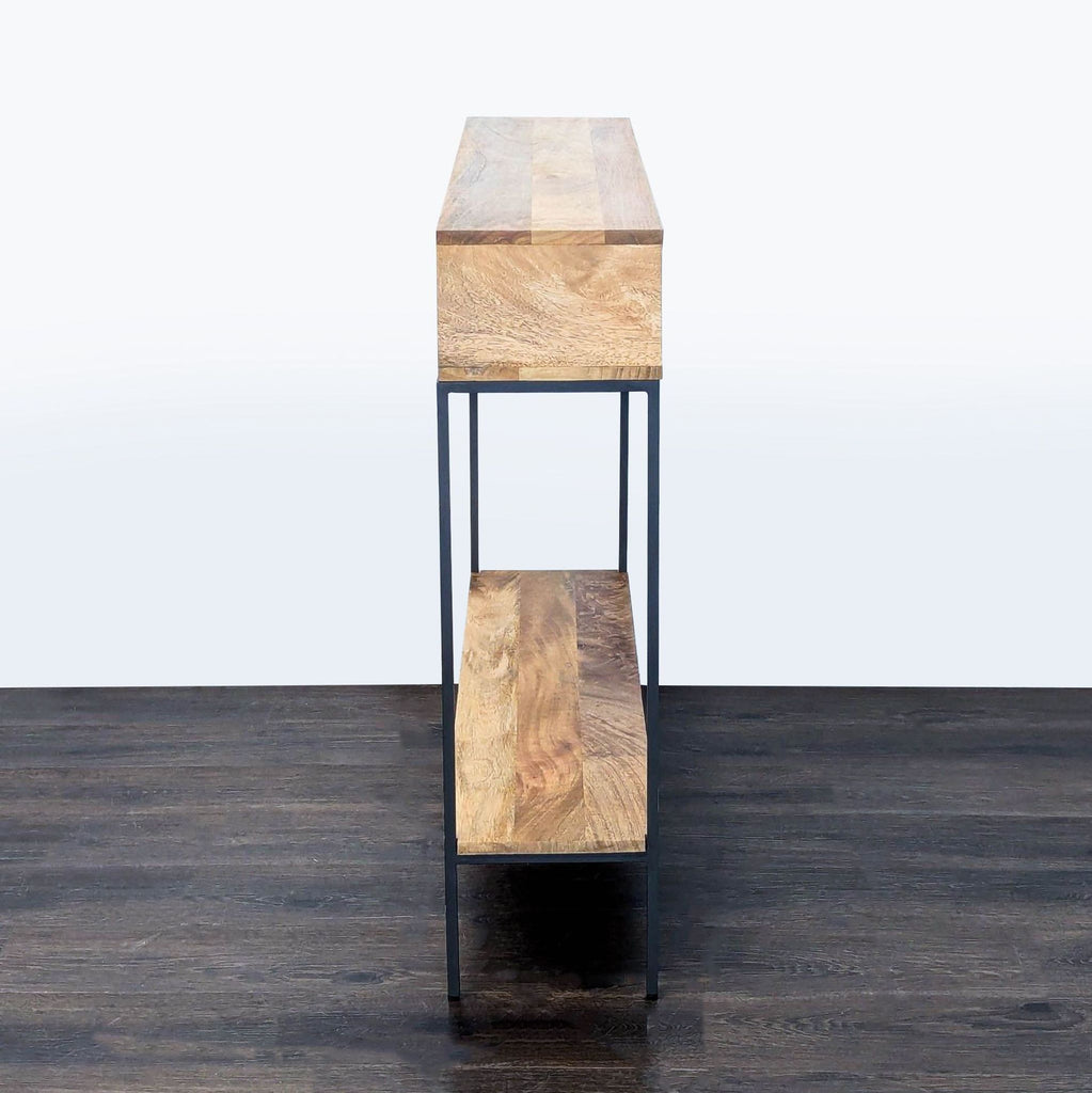 Sleek, black-framed console table by West Elm with mango wood, designed with two open cubbies.